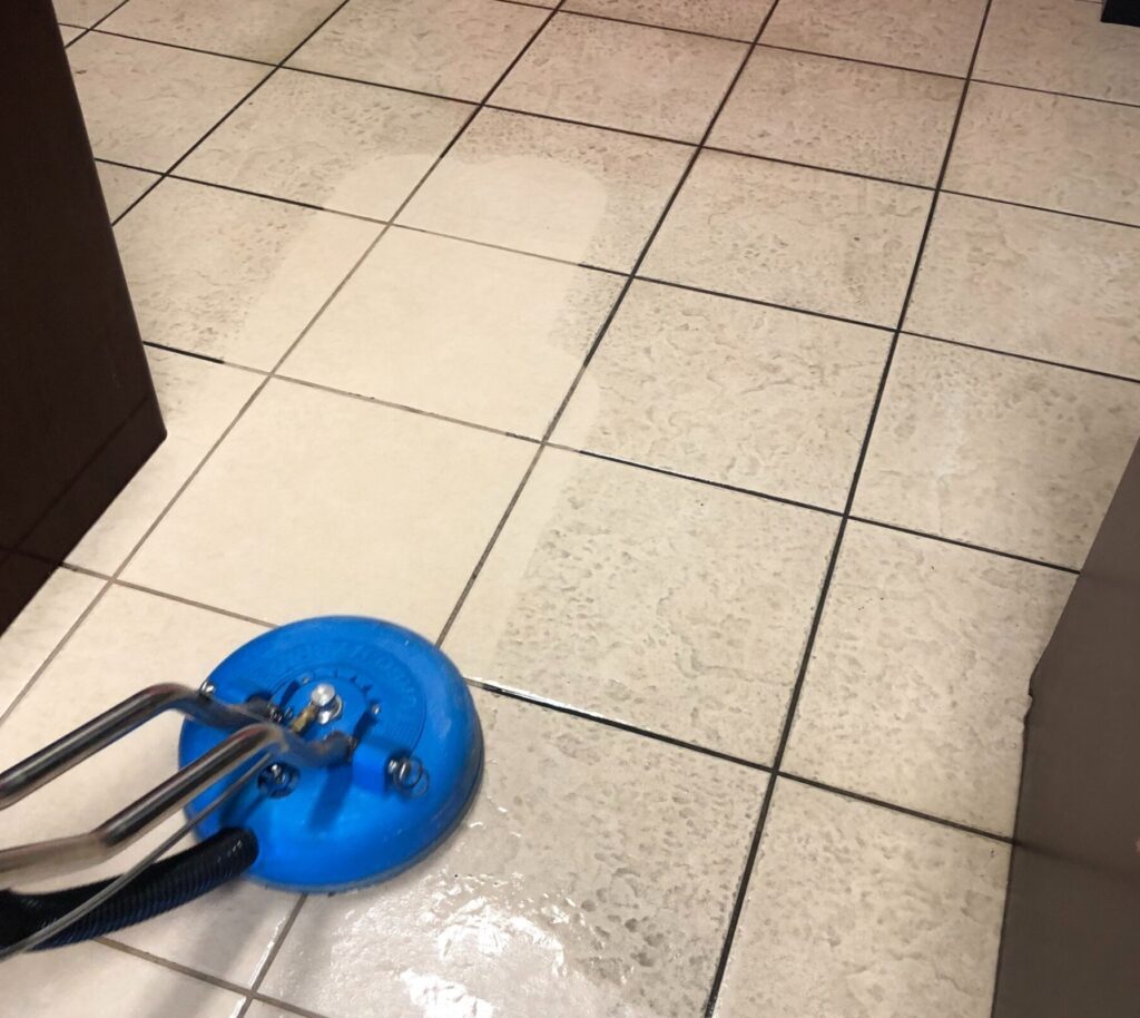 Tile floor being cleaned with a machine.